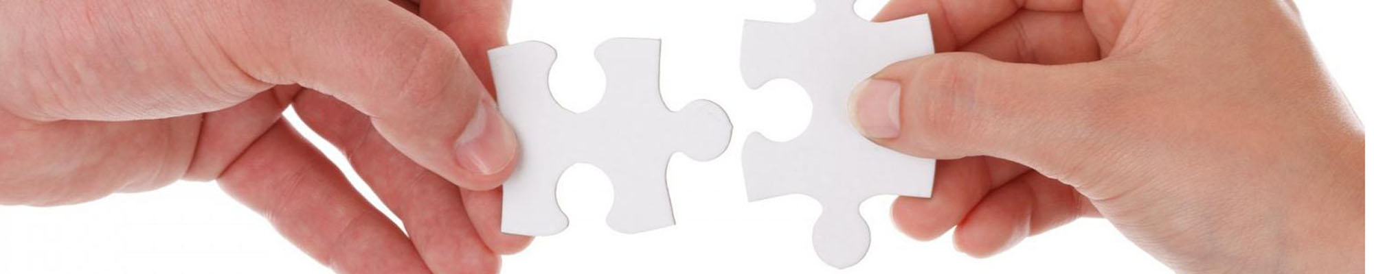 Two hands fitting matching puzzle pieces together